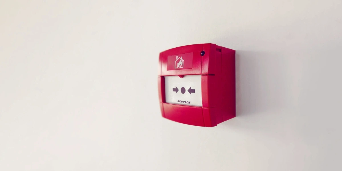 a fire alarm call point on a wall